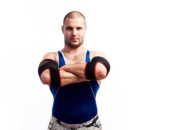 Mavi tayt ve siyah dirsek sportif delikanlı duruyor ve onun ellerini çapraz-over beyaz izole arka planda göğsüne tutar