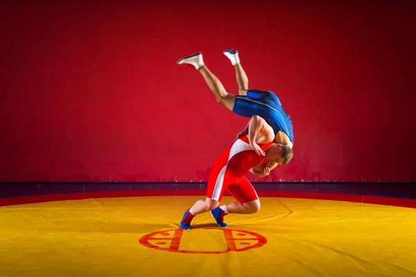 블루와 스타킹 레슬링에서 남자는 Wrestlng 엉덩이 노란색 체육관에서 카펫을 레슬링에 — 스톡 사진