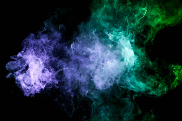 Dense multicolored smoke of blue,green on a black isolated background. Background of smoke vape