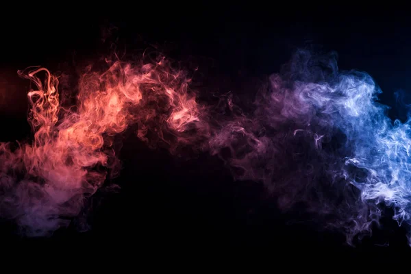 Thick colorful smoke of red and blue  on a black isolated background. Background from the smoke of vape