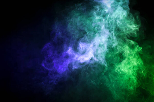 Colorful smoke of blue and green on a black isolated background. Background from the smoke of vape