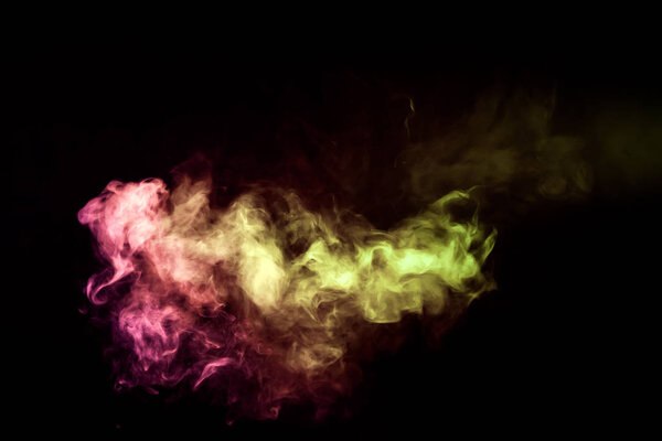 Colorful smoke of yellow, orange, pink on a black isolated background. Background from the smoke of vape