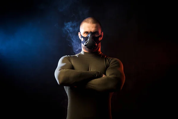 Man in training mask posing on black isolated — Stock Photo, Image