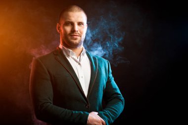 Genç yakışıklı Yöneticisi beyaz gömlek ve kırmızı ve mavi mendil izole siyah duman karşı poz yeşil ceketli adam...