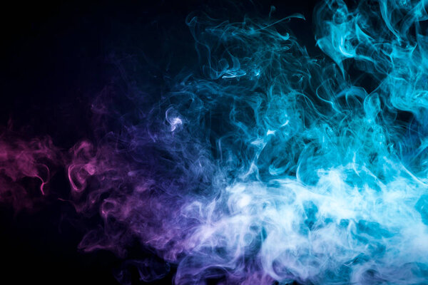 Pink and blue cloud of smoke of black isolated background. Background from the smoke of vape