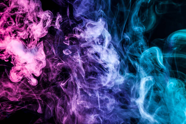 Colorful smoke of blue and pink on a black isolated background. Background from the smoke of vape
