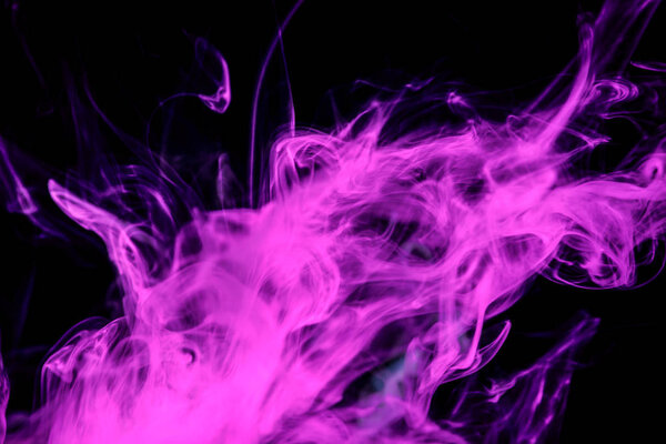 Dense multicolored smoke of pink colors on a black isolated background. Background of smoke vape