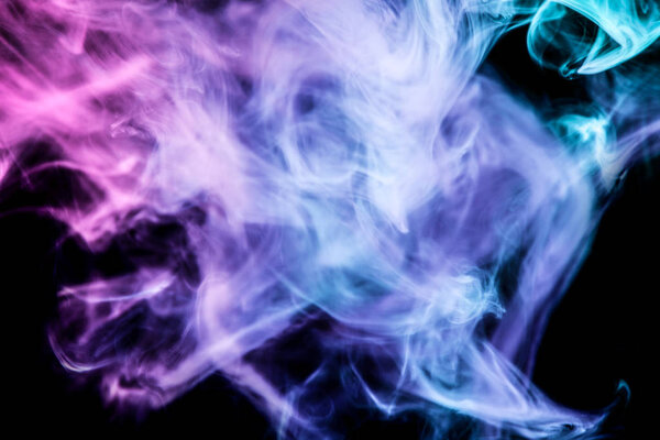 Thick colorful smoke of blue and purple on a black isolated background. Background from the smoke of vape
