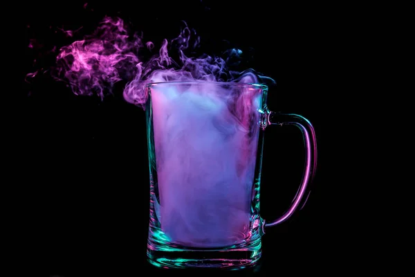 一个透明的玻璃啤酒充满了云从紫色 Vape 烟雾和站在黑色孤立的背景 — 图库照片