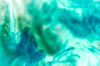 Beyaz izole zemin üzerinde mavi ve yeşil renklerin yoğun çok renkli duman. Arka planını duman vape