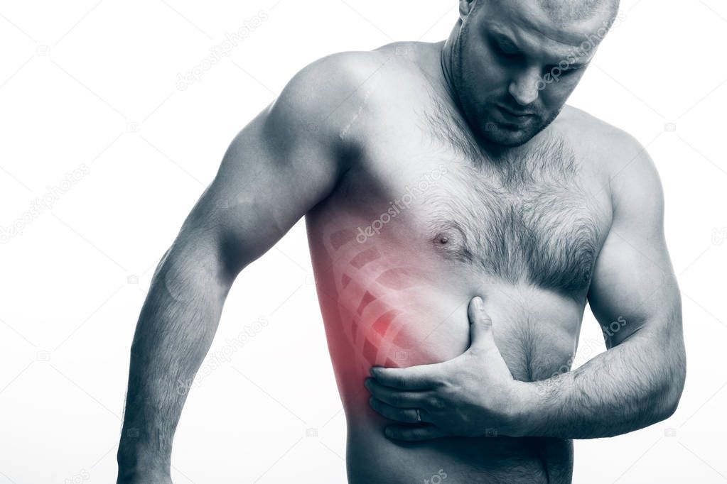 Injury of the rib. Young bald man sportive physique holds on sore rib isolated on white isolated background. Fracture of rib
