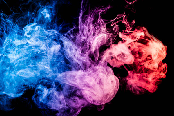 Thick colorful smoke of red and blue on a black isolated background. Background from the smoke of vape