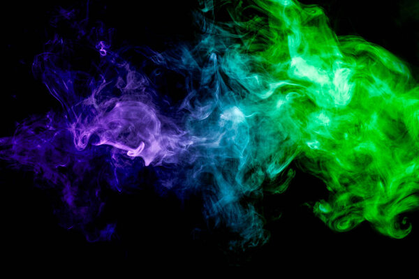 Dense multicolored smoke of green and blue colors on a black isolated background. Background of smoke vape