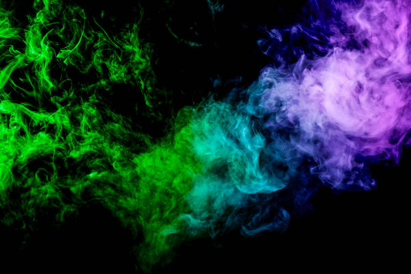 Thick pink and green colorful smoke of on a black isolated background. Background from the smoke of vape