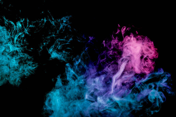 Thick pink and blue colorful smoke of on a black isolated background. Background from the smoke of vape