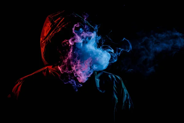 Joven Con Capucha Negra Fuma Vapor Exhala Humo Color Rojo — Foto de Stock