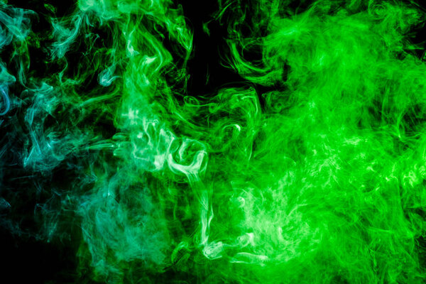 Green and blue cloud of smoke of black isolated background. Background from the smoke of vape