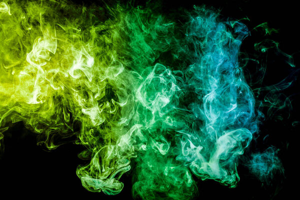 Green and blue cloud of smoke of black isolated background. Background from the smoke of vape