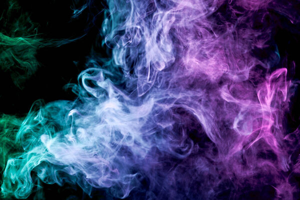 Green, purple and blue cloud of smoke of black isolated background. Background from the smoke of vape