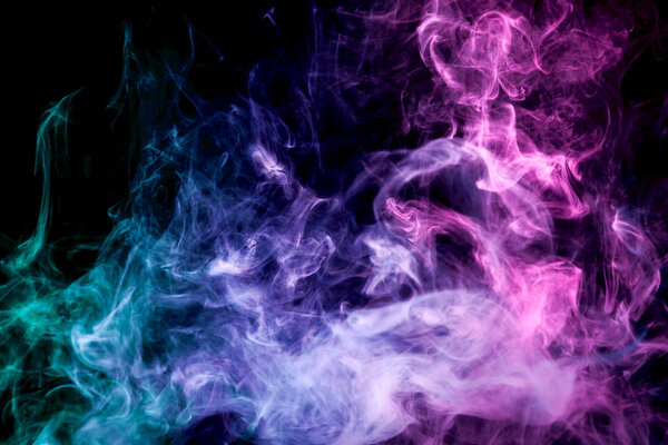 Pink, blue and green cloud of smoke of black isolated background. Background from the smoke of vape