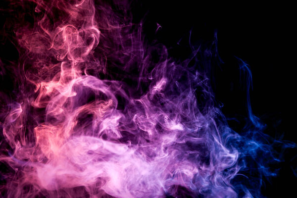 Pink, blue and purple cloud of smoke of black isolated background. Background from the smoke of vape