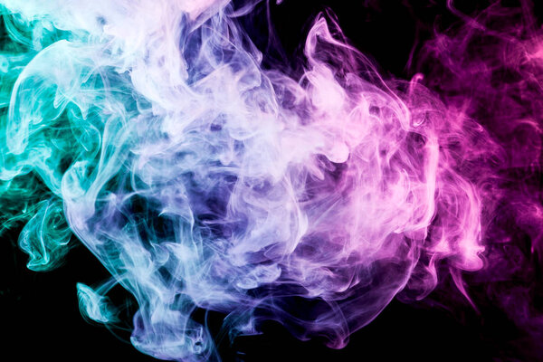 Pink, green and blue cloud of smoke of black isolated background. Background from the smoke of vape