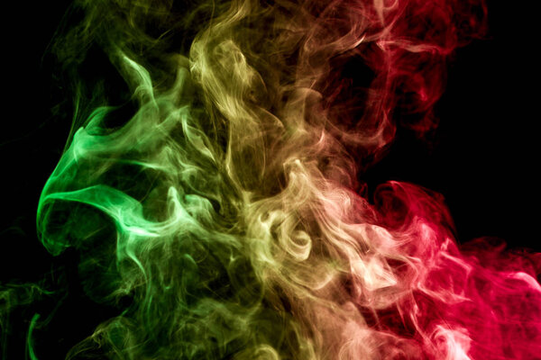 Pink, yellow and red cloud of smoke of black isolated background. Background from the smoke of vape