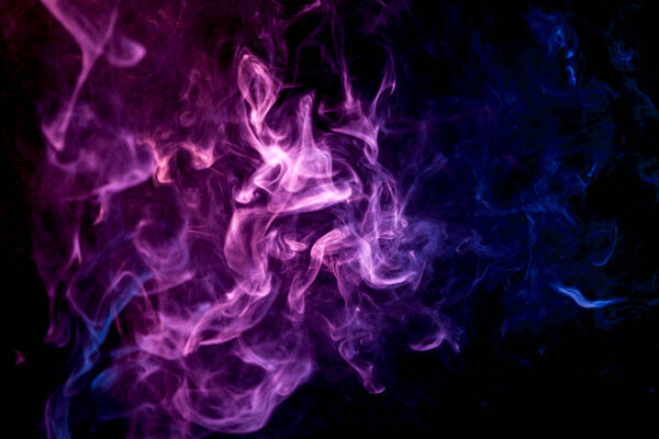 Purple and blue cloud of smoke of black isolated background. Background from the smoke of vape