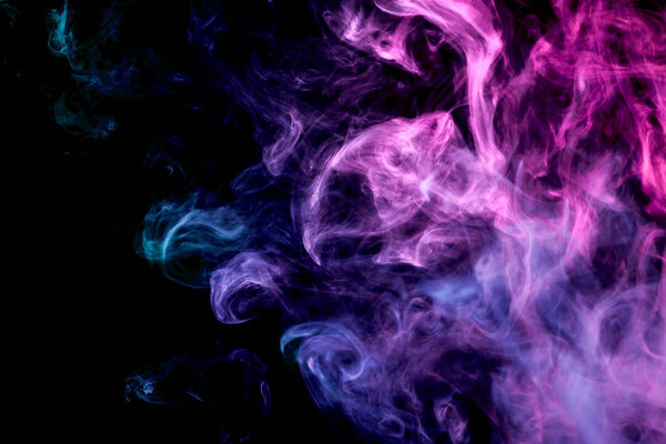 Dense multicolored smoke of blue, pink colors on a black isolated background. Background of smoke vape