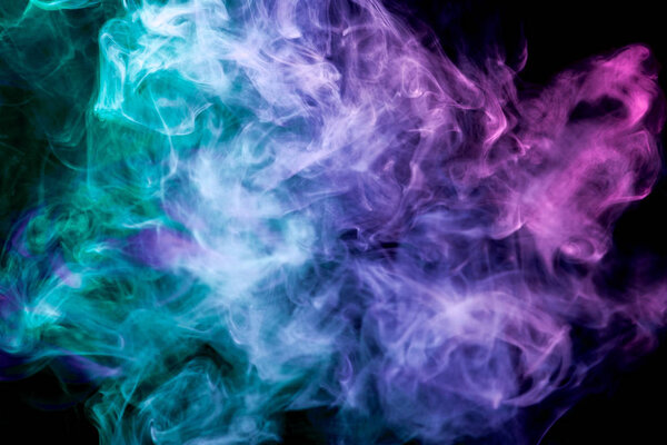 Dense multicolored smoke of blue, pink and green colors on a black isolated background. Background of smoke vape