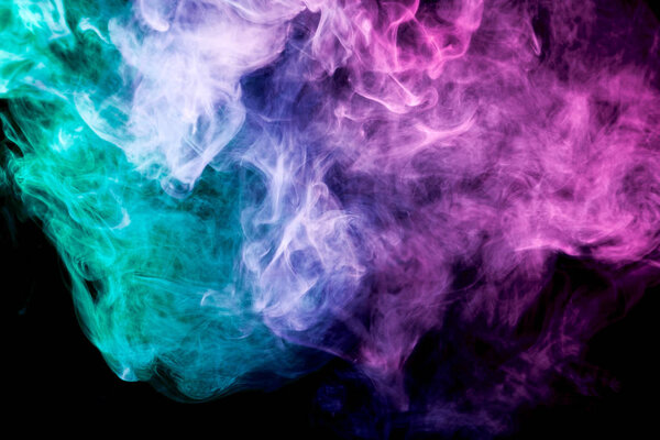 Thick colorful smoke of blue, pink and green on a black isolated background. Background from the smoke of vape