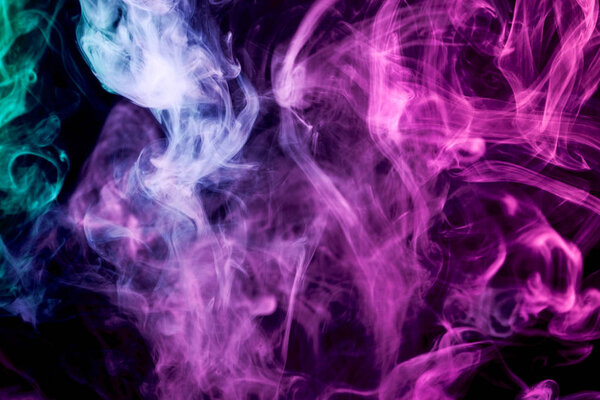 Dense multicolored smoke of pink, blue and purple colors on a black isolated background. Background of smoke vape