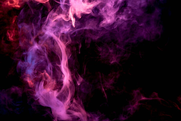 Dense multicolored smoke of pink, red and purple colors on a black isolated background. Background of smoke vape