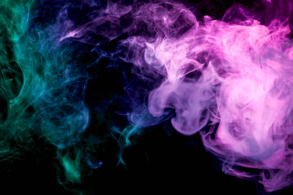 Thick colorful smoke of purple and green on a black isolated background. Background from the smoke of vapee