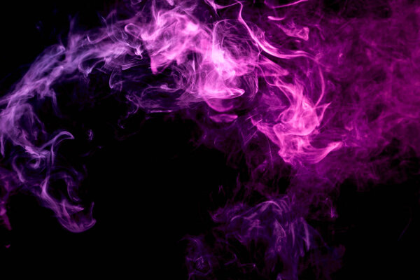 Thick colorful smoke of pink on a black isolated background. Background from the smoke of vapee