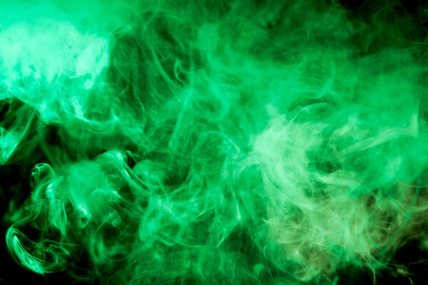 Dense green multicolored smoke on a black isolated background. Background of smoke vape