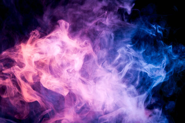 Thick blue, green and purple colorful smoke on a black isolated background. Background from the smoke of vape