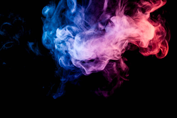 Thick red, blue and pink colorful smoke on a black isolated background. Background from the smoke of vape