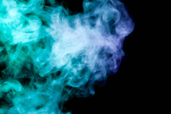 Thick colorful smoke of blue and purple on a black isolated background. Background from the smoke of vape