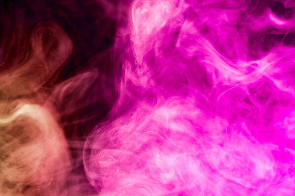 Dense multicolored smoke of pink and purple colors on a black isolated background. Background of smoke vape