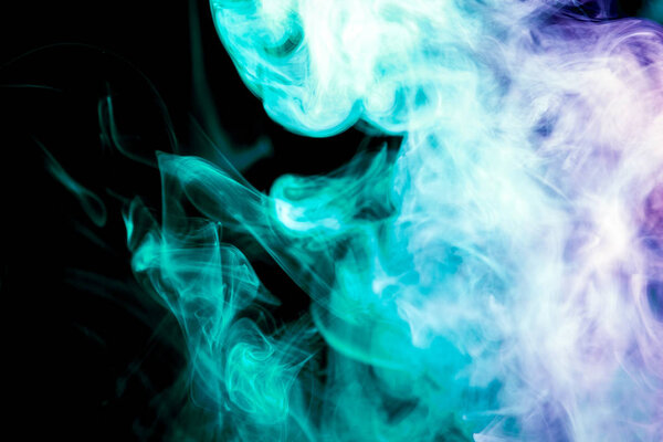 Colorful blue and green smoke on a black isolated background. Background from the smoke of vape