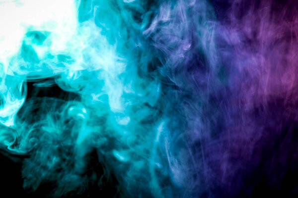 Colorful blue, green and pink smoke on a black isolated background. Background from the smoke of vape