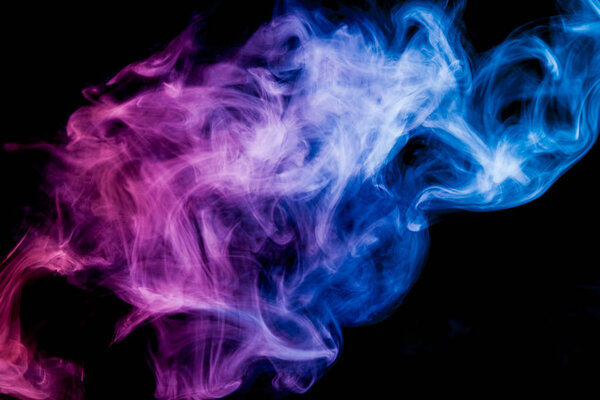 Thick colorful smoke of blue and pink on a black isolated background. Background from the smoke of vape