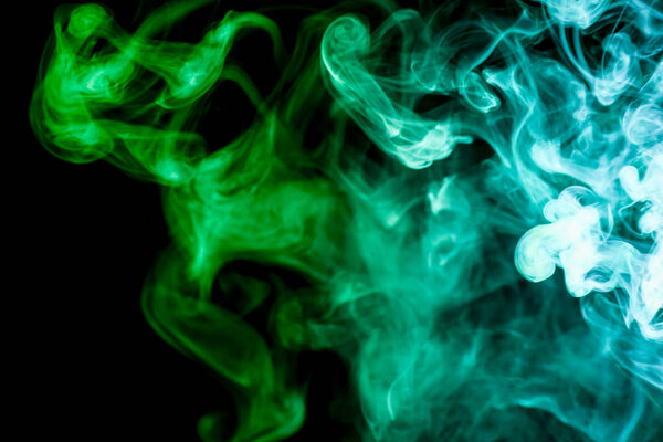 Dense green multicolored smoke on a black isolated background. Background of smoke vape