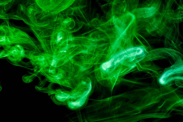 Green cloud of smoke of black isolated background. Background from the smoke of vape