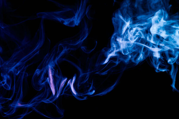Dense blue multicolored smoke on a black isolated background. Background of smoke vape