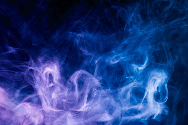 Dense blue multicolored smoke on a black isolated background. Background of smoke vape