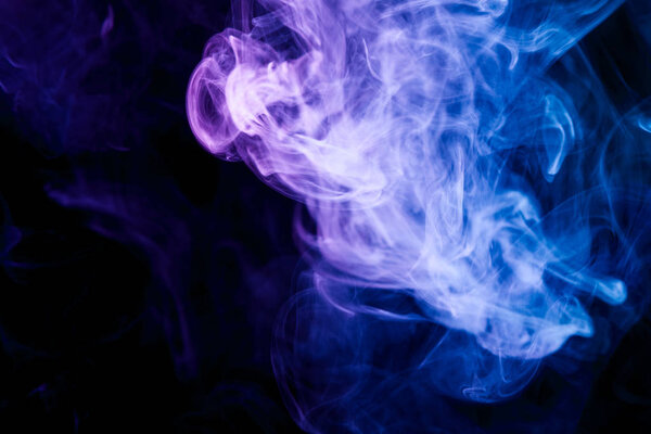 Colorful purple and blue smoke on a black isolated background. Background from the smoke of vape