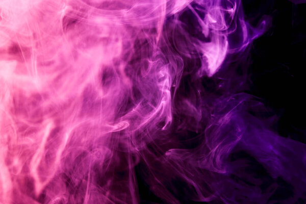 Thick colorful pink and purple smoke on a black isolated background. Background from the smoke of vape