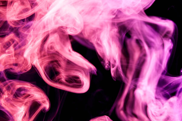 Thick colorful pink and purple smoke on a black isolated background. Background from the smoke of vape